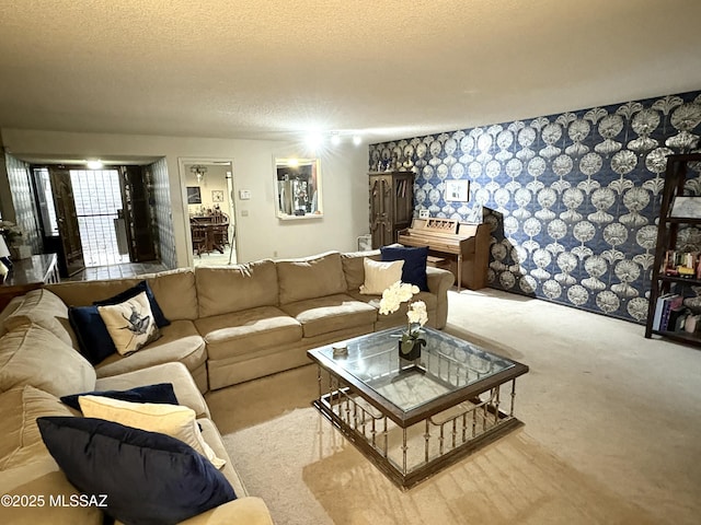 living room with a textured ceiling, wallpapered walls, and carpet