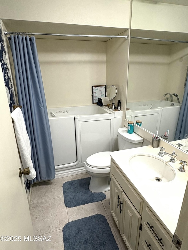 full bath with curtained shower, washing machine and dryer, toilet, a bathing tub, and vanity