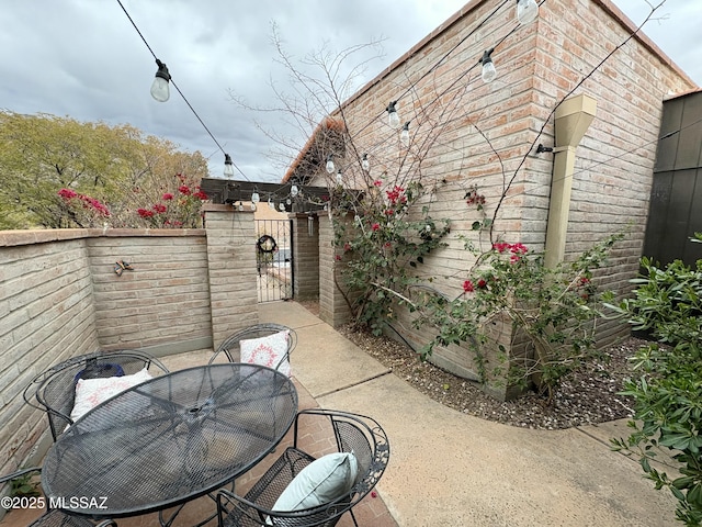 view of patio / terrace with fence, outdoor dining space, and a gate