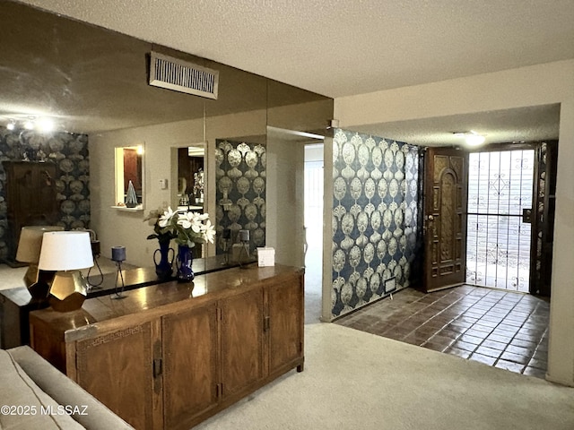 wine room with tile patterned flooring, visible vents, a textured ceiling, and carpet floors