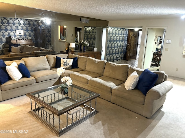 carpeted living room featuring wallpapered walls, baseboards, and a textured ceiling