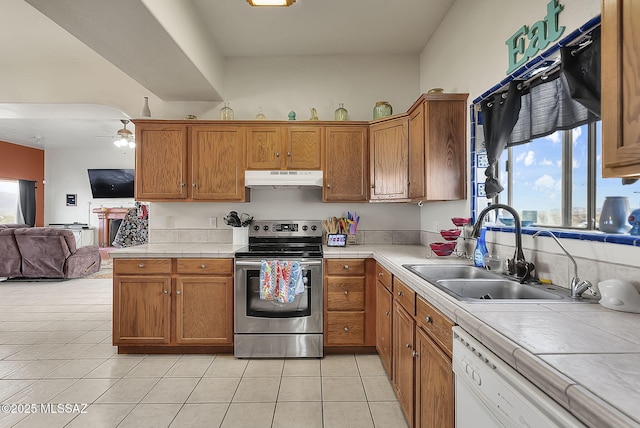 kitchen featuring sink, tile countertops, white dishwasher, ceiling fan, and stainless steel electric stove