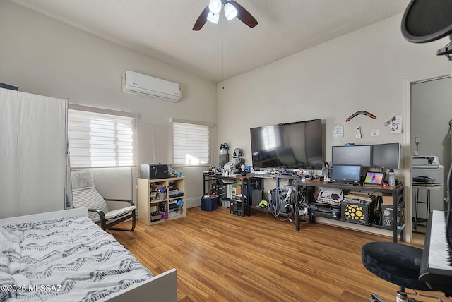 bedroom featuring lofted ceiling, hardwood / wood-style flooring, an AC wall unit, and ceiling fan