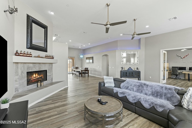 living room with ceiling fan, a premium fireplace, and hardwood / wood-style floors