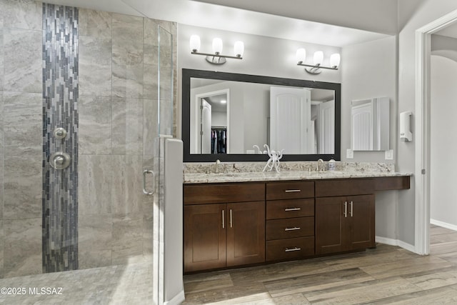 bathroom with vanity, wood-type flooring, and walk in shower