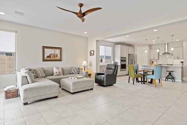 tiled living room featuring ceiling fan