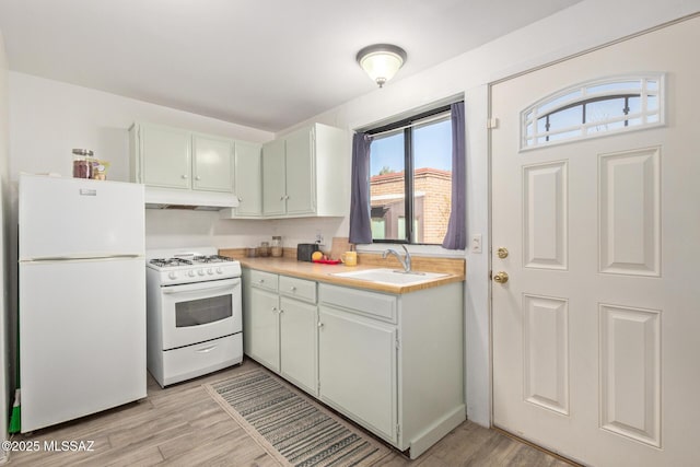 kitchen featuring sink, white appliances, and light hardwood / wood-style floors