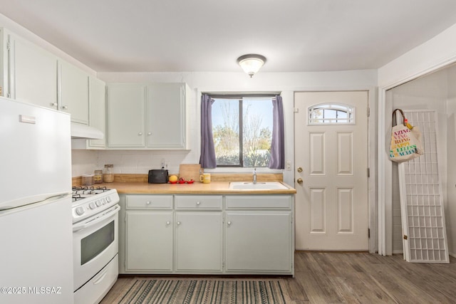 kitchen featuring dark hardwood / wood-style flooring, sink, white appliances, and tasteful backsplash