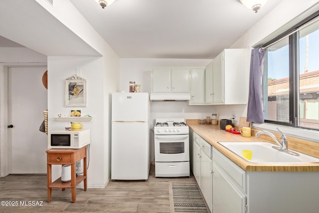 kitchen with white cabinets, white appliances, sink, and light wood-type flooring