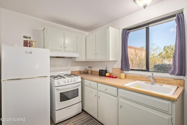 kitchen featuring white cabinetry, sink, and white appliances