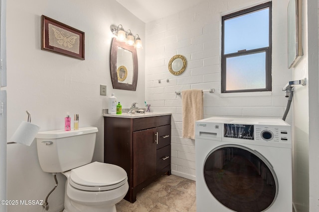 bathroom with vanity, washer / clothes dryer, and toilet