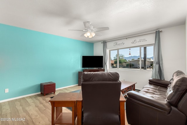 living room with ceiling fan and light hardwood / wood-style flooring