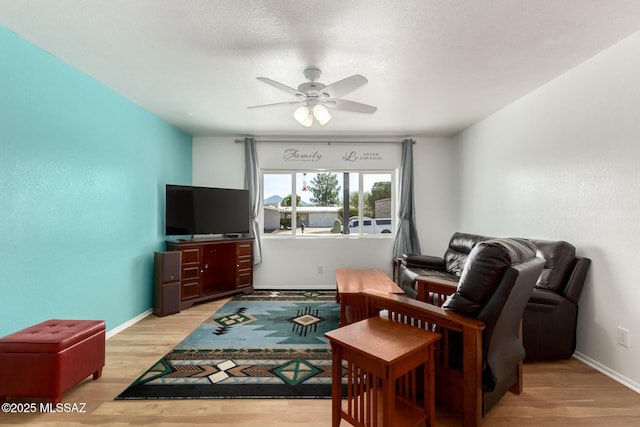 living room featuring a textured ceiling, light hardwood / wood-style floors, and ceiling fan