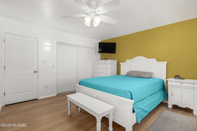 bedroom with ceiling fan, a closet, and light hardwood / wood-style flooring