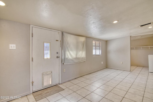 foyer entrance featuring tile patterned floors, washer / clothes dryer, baseboards, and visible vents
