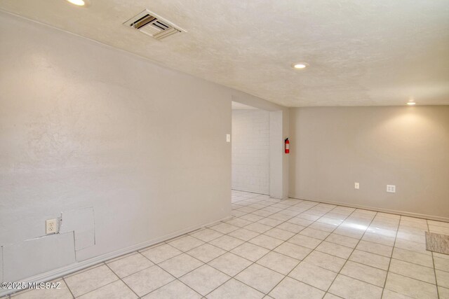 spare room featuring vaulted ceiling and light tile patterned floors