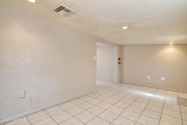 empty room featuring light tile patterned floors, recessed lighting, baseboards, and visible vents
