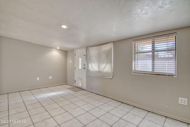 unfurnished room with baseboards, a textured ceiling, recessed lighting, and light tile patterned floors