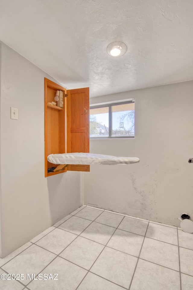 bathroom featuring tile patterned flooring and a textured ceiling