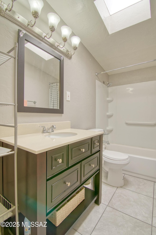 bathroom with a skylight, toilet, tile patterned floors, vanity, and shower / bath combo with shower curtain