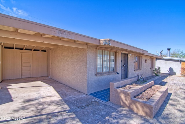 view of front of home featuring stucco siding and an attached carport