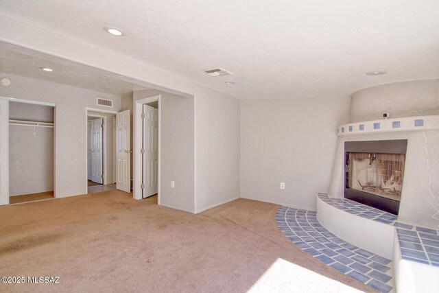 unfurnished living room with carpet flooring, recessed lighting, and visible vents
