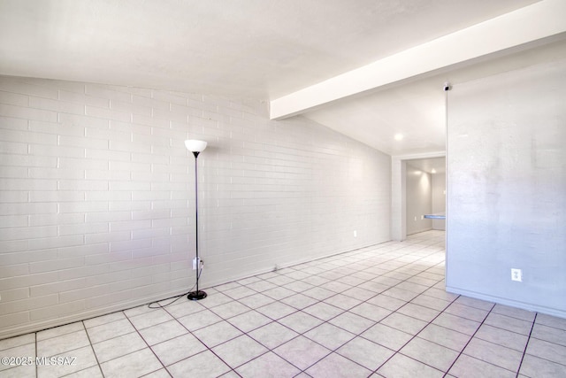 unfurnished room with lofted ceiling with beams and brick wall