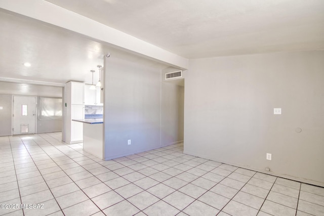 unfurnished room with visible vents, vaulted ceiling, and light tile patterned floors