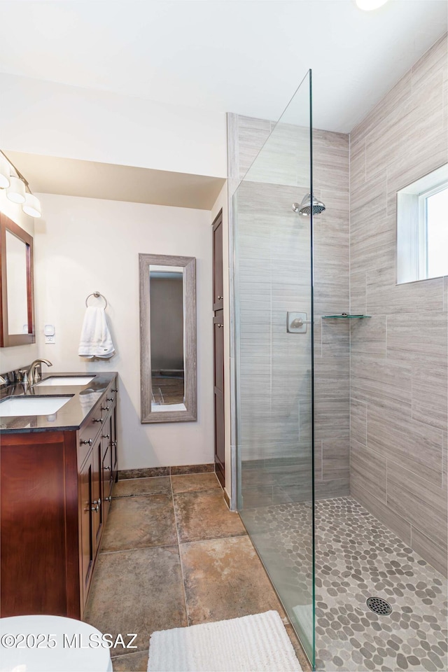 bathroom with vanity and a tile shower