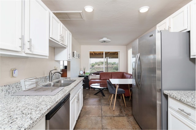 kitchen featuring white cabinetry, sink, light stone counters, and stainless steel appliances