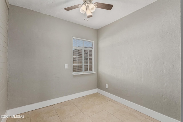 tiled spare room with ceiling fan