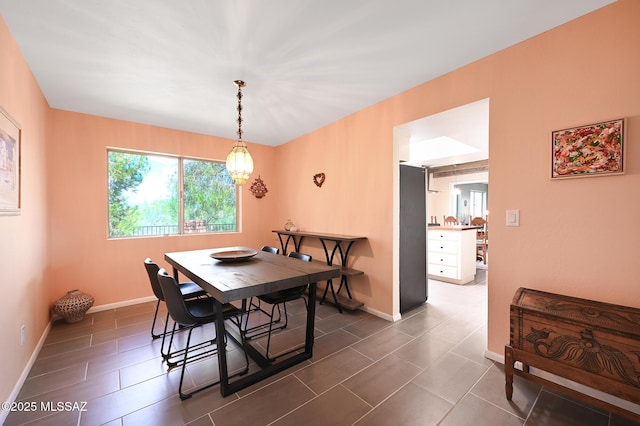 tiled dining space featuring a chandelier