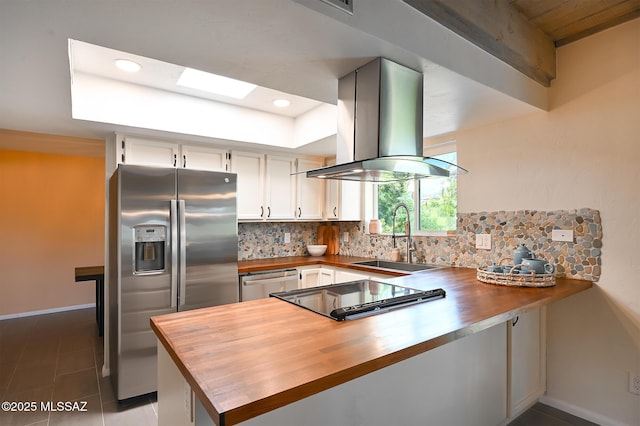 kitchen with appliances with stainless steel finishes, island range hood, kitchen peninsula, and sink