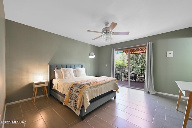 bedroom with ceiling fan, dark tile patterned floors, and access to outside