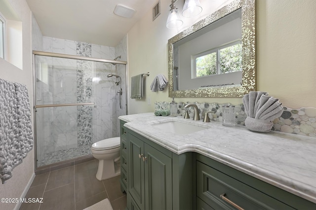 bathroom featuring tile patterned floors, vanity, toilet, and an enclosed shower