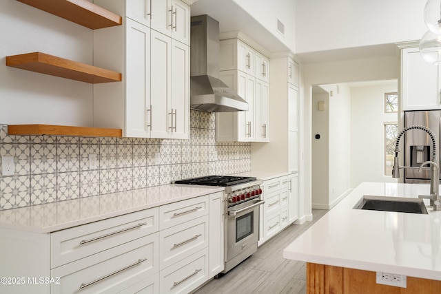 kitchen featuring visible vents, light countertops, wall chimney range hood, appliances with stainless steel finishes, and backsplash