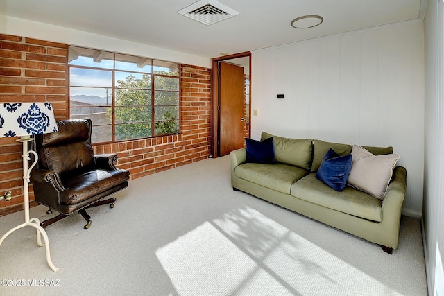 living room with brick wall and carpet flooring