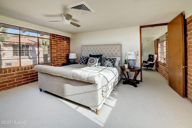 bedroom featuring ceiling fan, light colored carpet, and brick wall