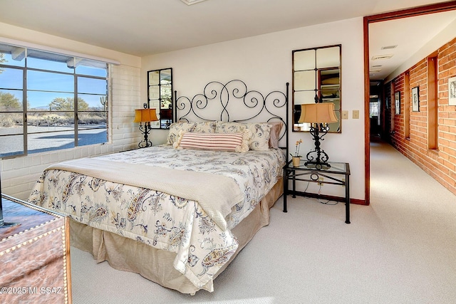 carpeted bedroom with brick wall