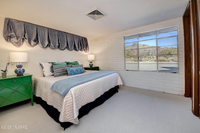 carpeted bedroom with brick wall