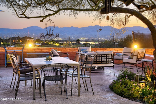 patio terrace at dusk with an outdoor living space and a mountain view