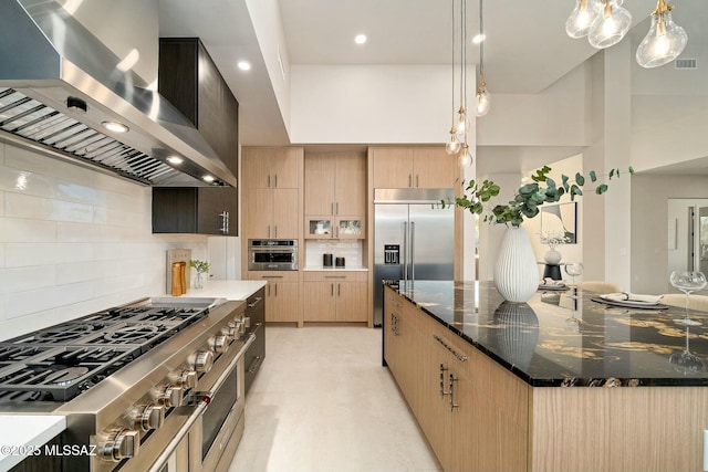 kitchen featuring a spacious island, light brown cabinetry, high quality appliances, dark stone counters, and exhaust hood