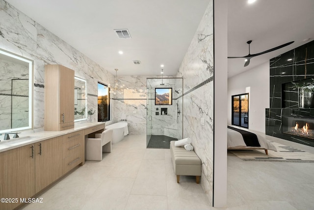 bathroom with ceiling fan, tile walls, vanity, plus walk in shower, and tile patterned floors