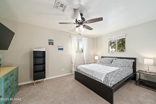 carpeted bedroom with ceiling fan and multiple windows