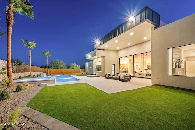 yard at twilight featuring a fenced in pool, a patio, and an outdoor living space