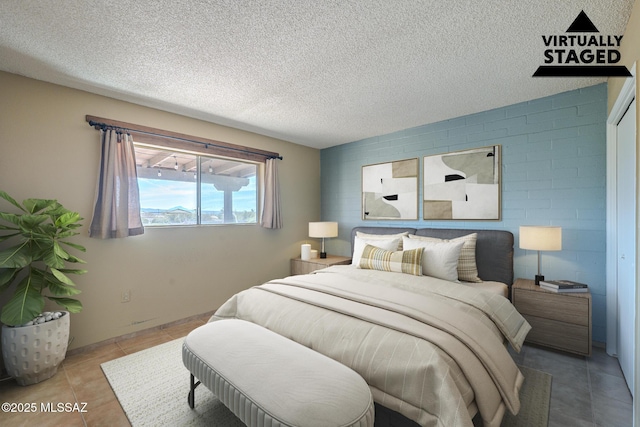 bedroom featuring tile patterned flooring and a textured ceiling