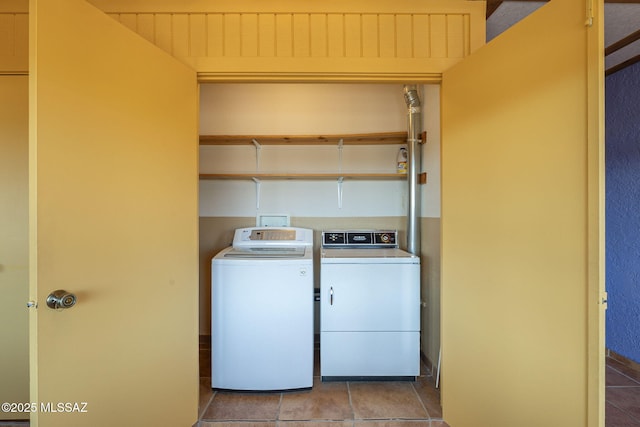 clothes washing area with light tile patterned floors and washing machine and clothes dryer