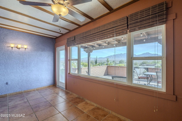 tiled empty room with a mountain view and ceiling fan