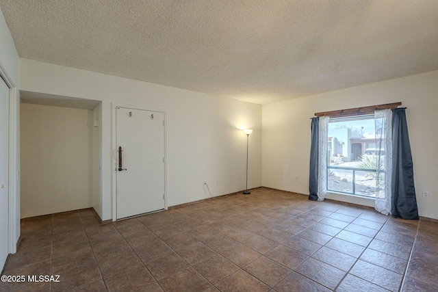 unfurnished room featuring tile patterned floors and a textured ceiling