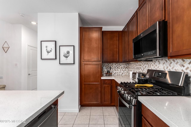 kitchen featuring light stone countertops, appliances with stainless steel finishes, and backsplash